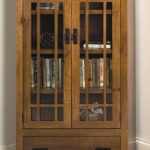 Mission Bookcase with drawer and wood framed glass doors .