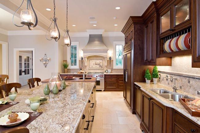A large kitchen with dark brown cabinets, cream-colored tile .