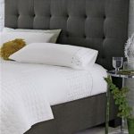 charcoal grey, upholstered headboard with white linens | Gray .