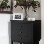 A simple black chest of drawers made from solid timber with a .