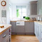Country kitchen with grey painted cabinetry and wooden worktops .