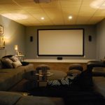 Basement media room with sectional sofa and giraffe texture .