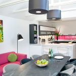 Monochrome kitchen diner with colourful artwork, sofa and bright .