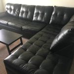 A slightly used, black leather, 2 piece sectional couch .