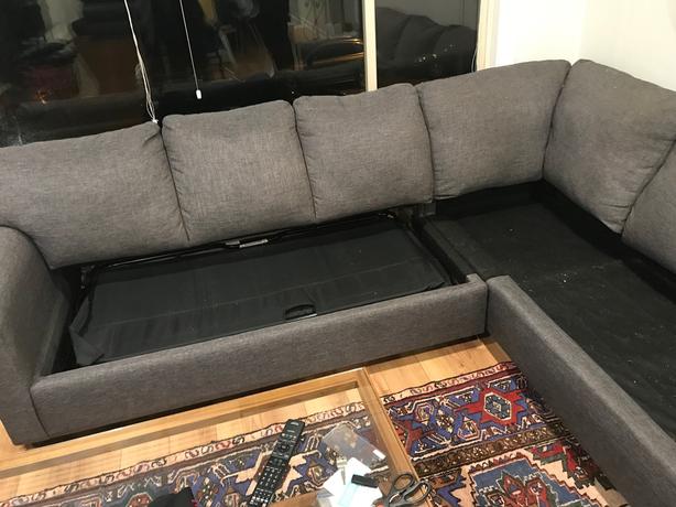Grey sectional couch w/ pull out bed - excellent condition .