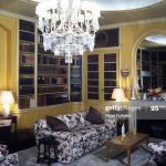The library with chandelier, chintz sofas, and yellow walls at .
