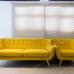 Modern yellow sofa and chair in room interior at home or hotel photo .